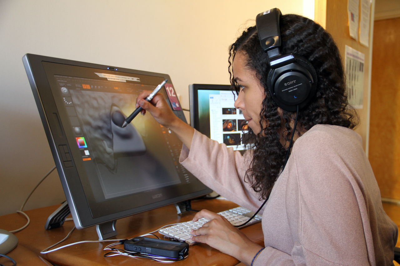 Woman using a stylus to draw on a computer screen